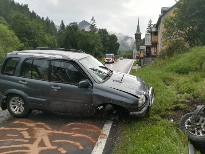 Pkw steht beschädigt am Straßenrand. Ein Reifen fehlt