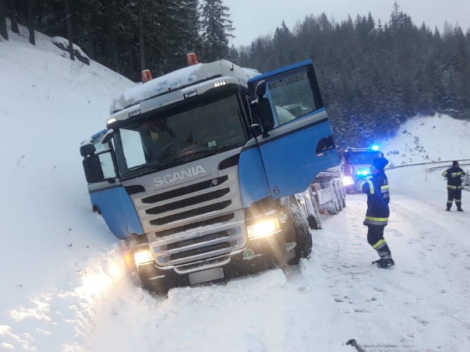 Blauer Lkw hängt mit rechten Seite tief im Straßengraben